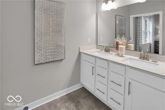 bathroom featuring double vanity, a sink, and baseboards