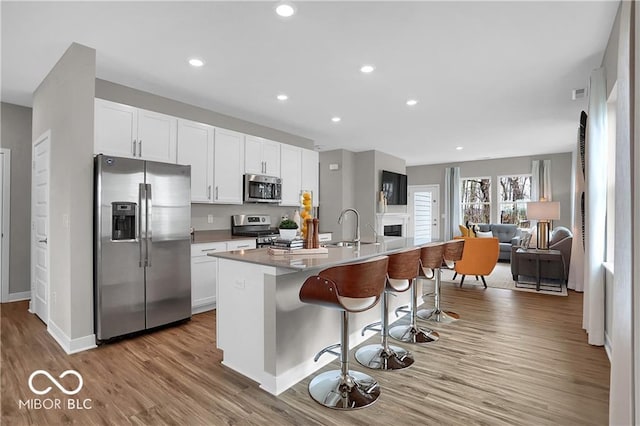 kitchen featuring appliances with stainless steel finishes, white cabinets, and a sink