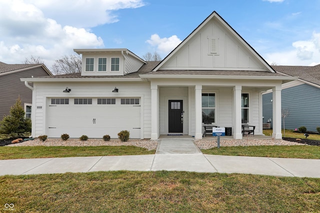 view of front facade with board and batten siding, a front yard, a porch, and a garage