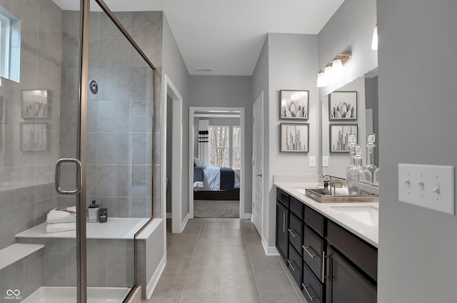 ensuite bathroom featuring double vanity, baseboards, connected bathroom, tile patterned floors, and a shower stall