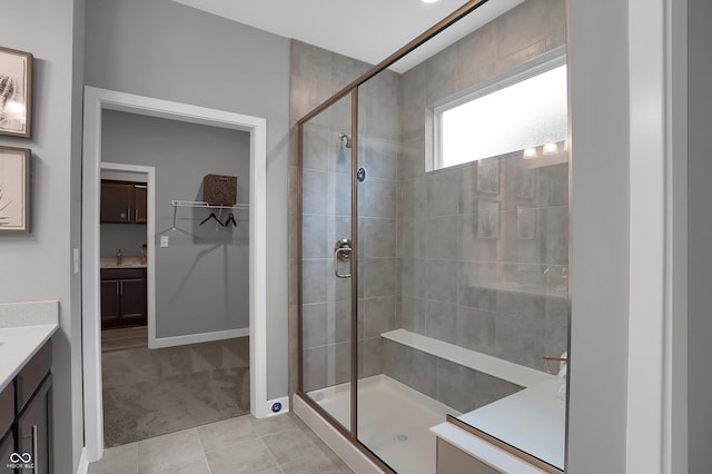 full bathroom featuring tile patterned floors, a shower stall, baseboards, and vanity