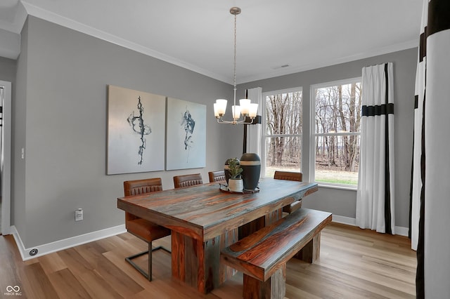 dining room featuring light wood-type flooring, a healthy amount of sunlight, visible vents, and crown molding