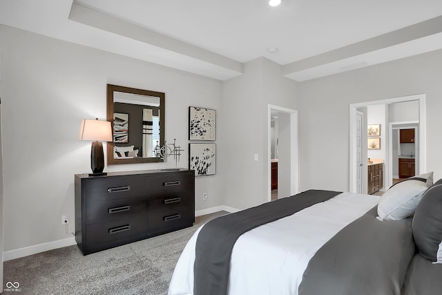 carpeted bedroom featuring ensuite bathroom and baseboards