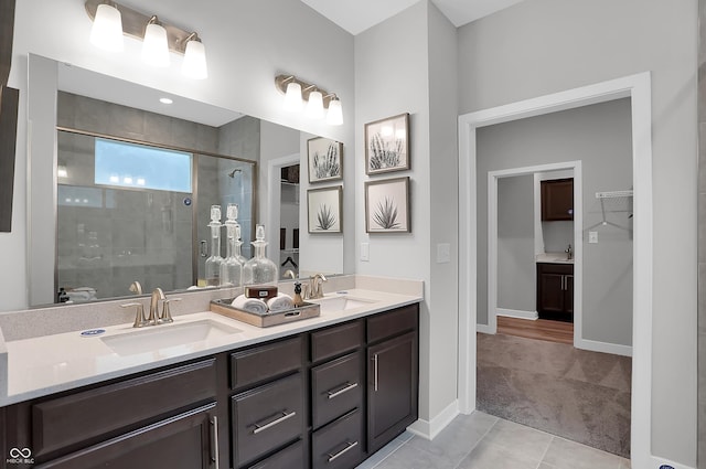 full bathroom with a stall shower, tile patterned floors, a sink, and double vanity