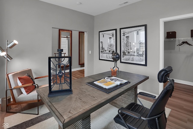 home office featuring wood finished floors, visible vents, and baseboards