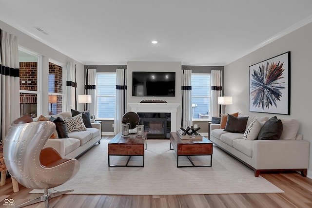 living area featuring plenty of natural light, wood finished floors, and visible vents