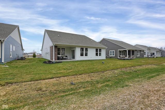 rear view of house featuring brick siding, a yard, central AC unit, and a patio