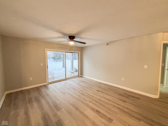 empty room featuring a textured ceiling, ceiling fan, and wood-type flooring