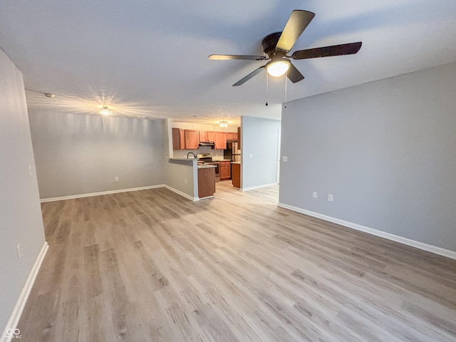 unfurnished living room featuring ceiling fan and light wood-type flooring