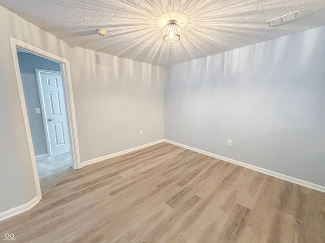 spare room with wood-type flooring and a textured ceiling