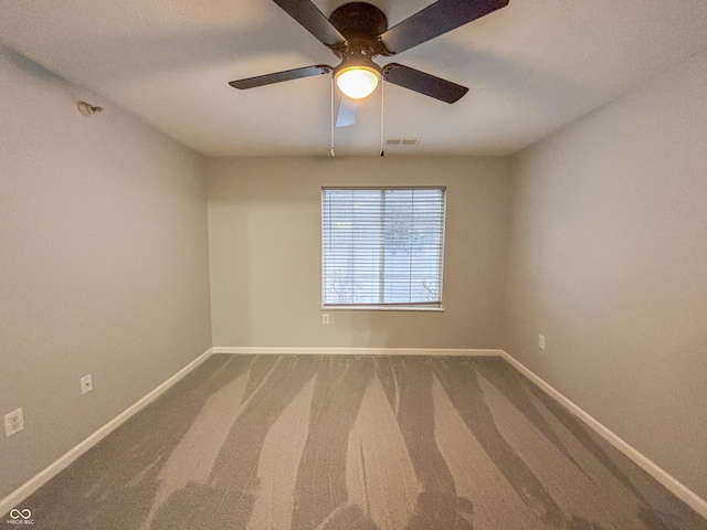 unfurnished room with ceiling fan and carpet