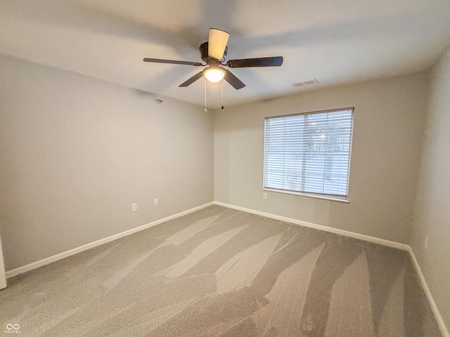 carpeted spare room with ceiling fan