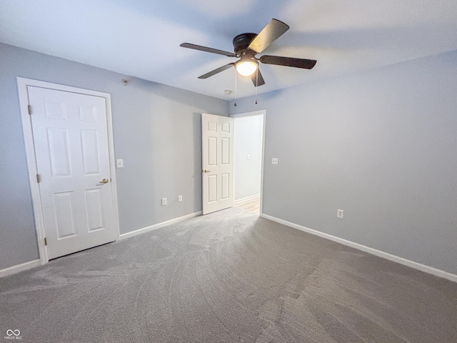 unfurnished room with ceiling fan and carpet