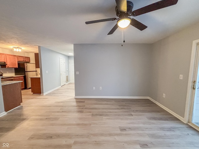 unfurnished living room featuring ceiling fan and light hardwood / wood-style floors