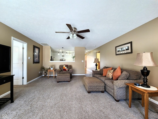 carpeted living room with a textured ceiling and ceiling fan