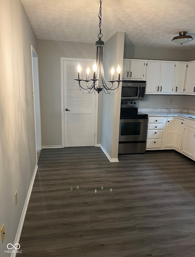 kitchen featuring dark hardwood / wood-style flooring, white cabinets, hanging light fixtures, and appliances with stainless steel finishes