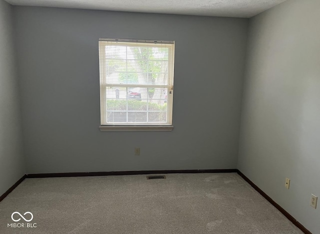 carpeted spare room with a textured ceiling