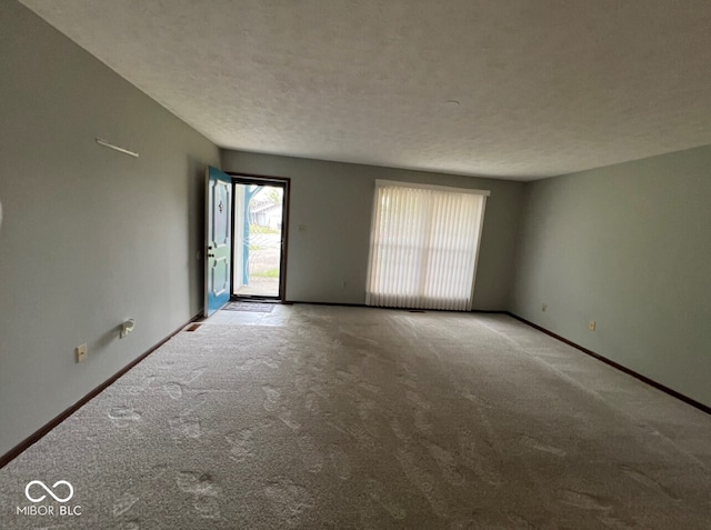 carpeted spare room featuring a textured ceiling