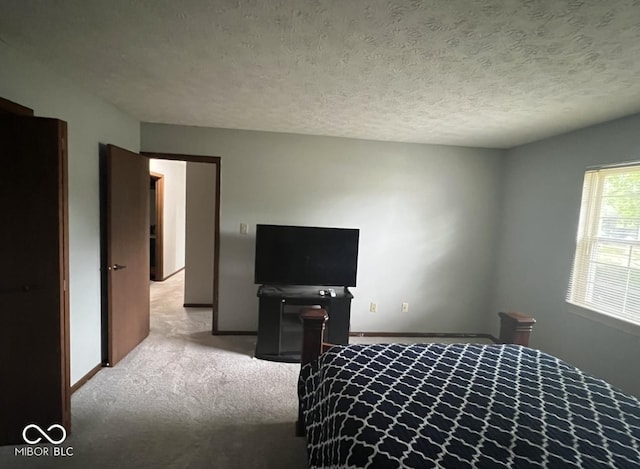 bedroom featuring a textured ceiling and light carpet