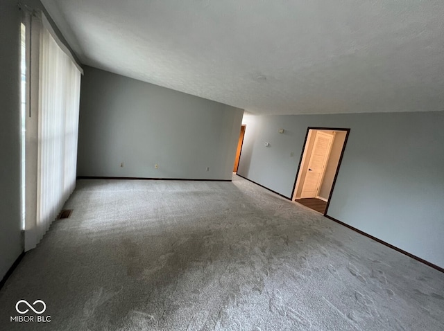 empty room with a textured ceiling and carpet floors