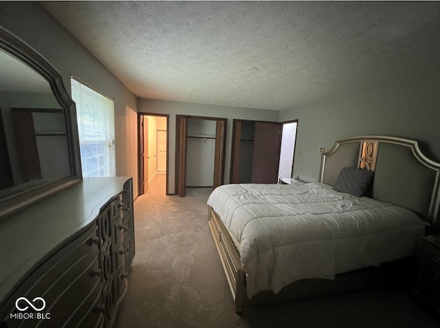 bedroom with a textured ceiling and light carpet