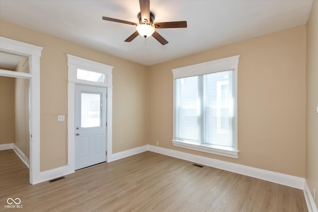 foyer entrance with ceiling fan, a healthy amount of sunlight, and light wood-type flooring