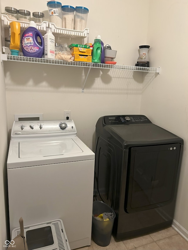 laundry area featuring washing machine and clothes dryer and light tile patterned floors