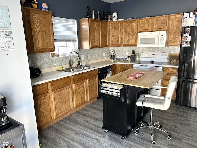 kitchen featuring sink, a kitchen breakfast bar, hardwood / wood-style floors, wooden counters, and black appliances