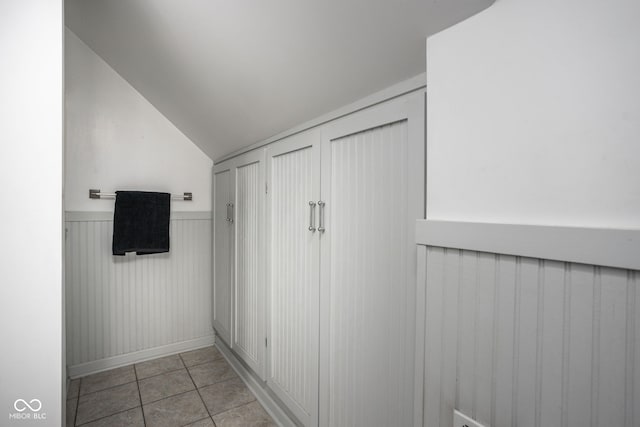 interior space with lofted ceiling and light tile patterned floors