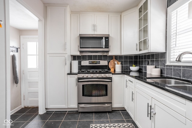 kitchen featuring stainless steel appliances, white cabinets, and sink