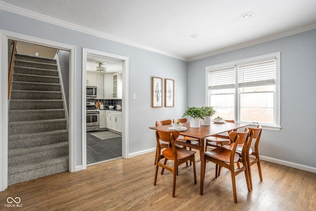 dining area with light wood-type flooring and crown molding