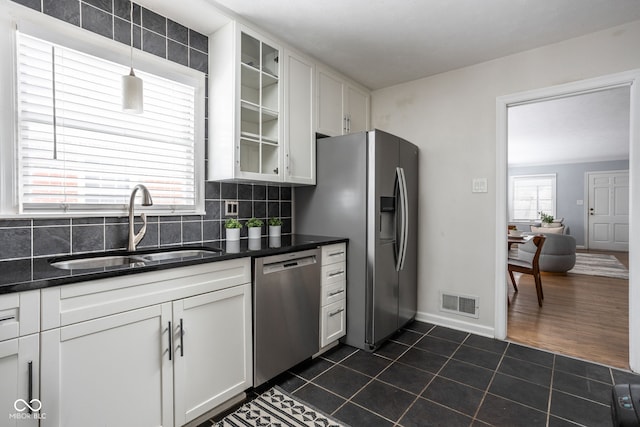 kitchen featuring appliances with stainless steel finishes, hanging light fixtures, white cabinets, and sink