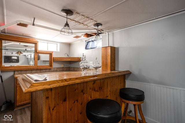 bar featuring dark hardwood / wood-style flooring and hanging light fixtures