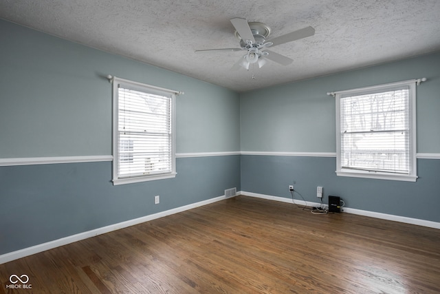 empty room with a textured ceiling, ceiling fan, and a healthy amount of sunlight