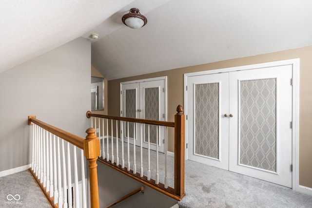 hallway with french doors, vaulted ceiling, and light carpet