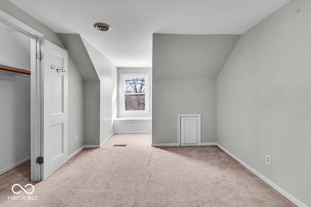 bonus room featuring vaulted ceiling and light colored carpet