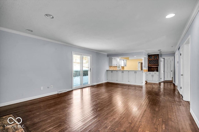 unfurnished living room featuring dark wood-type flooring and crown molding