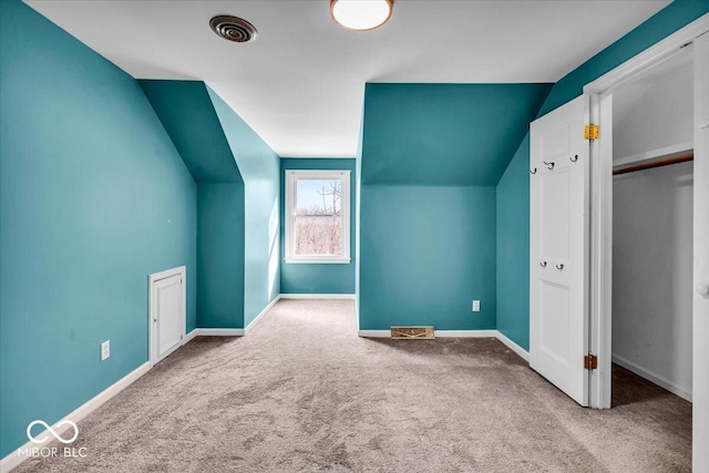 additional living space with vaulted ceiling and carpet flooring