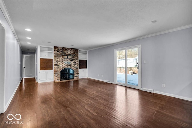 unfurnished living room with hardwood / wood-style floors, a fireplace, ornamental molding, and built in shelves