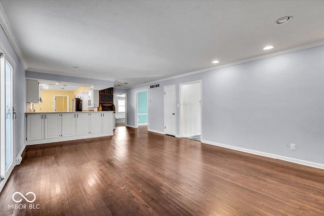 unfurnished living room featuring dark hardwood / wood-style flooring and ornamental molding