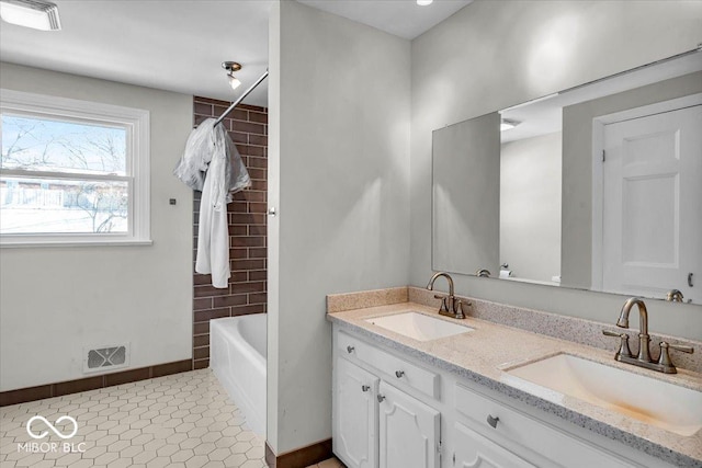 bathroom featuring tile patterned flooring, shower / washtub combination, and vanity