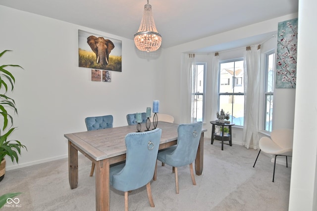 dining room featuring light colored carpet and a chandelier