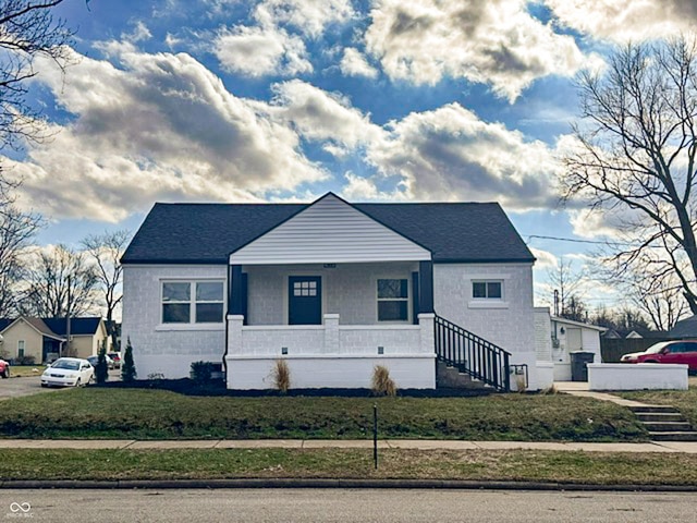 bungalow-style house with a front yard and covered porch