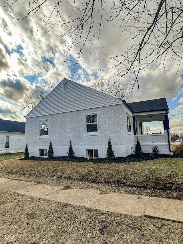 view of side of property featuring central AC unit and a lawn