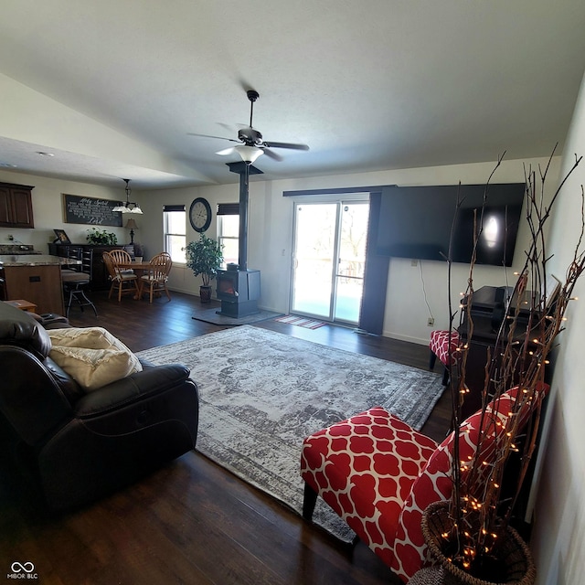 living room featuring a wood stove, ceiling fan, and dark hardwood / wood-style floors