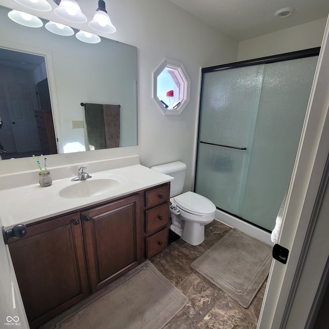 bathroom featuring vanity, toilet, and walk in shower