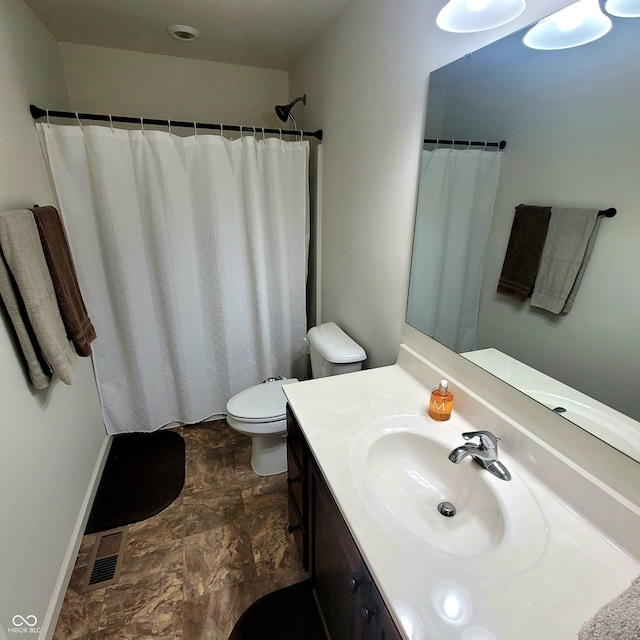 bathroom featuring vanity, toilet, and curtained shower