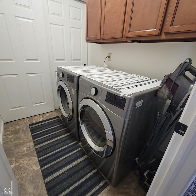 laundry area with washing machine and dryer and cabinets