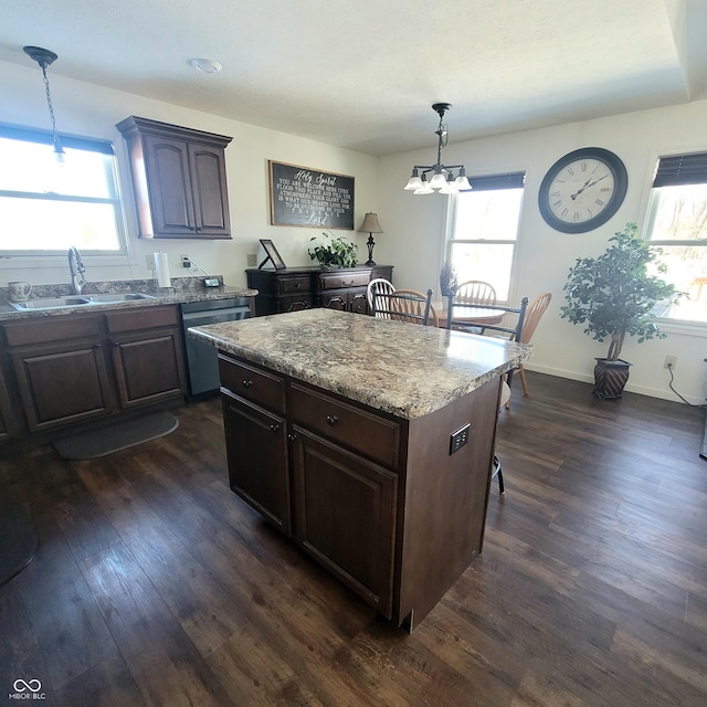 kitchen featuring sink, dark hardwood / wood-style flooring, plenty of natural light, pendant lighting, and a kitchen island