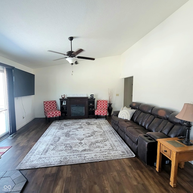 living room featuring a fireplace, dark hardwood / wood-style flooring, and ceiling fan